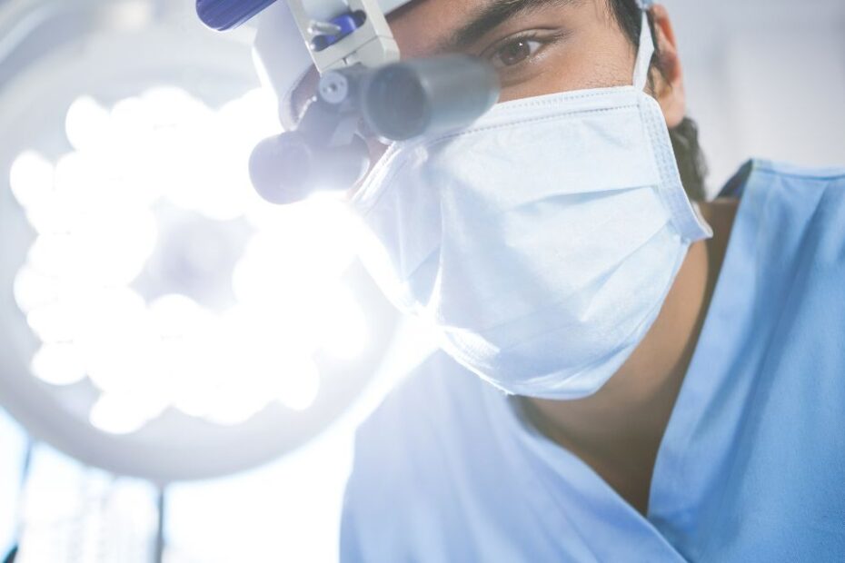 Male dentist wearing dental loupes