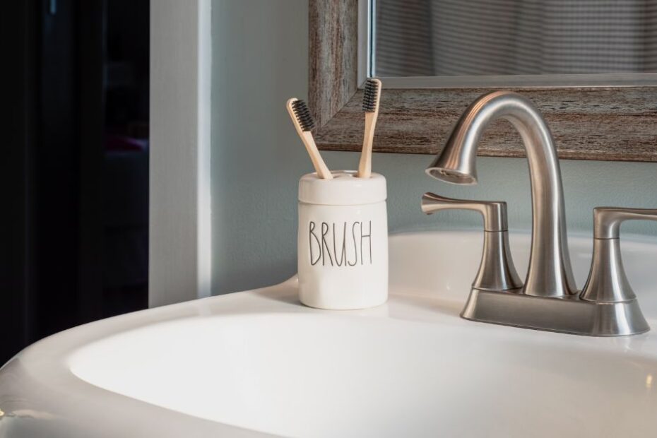 A bathroom sink with a toothbrush holder next to it