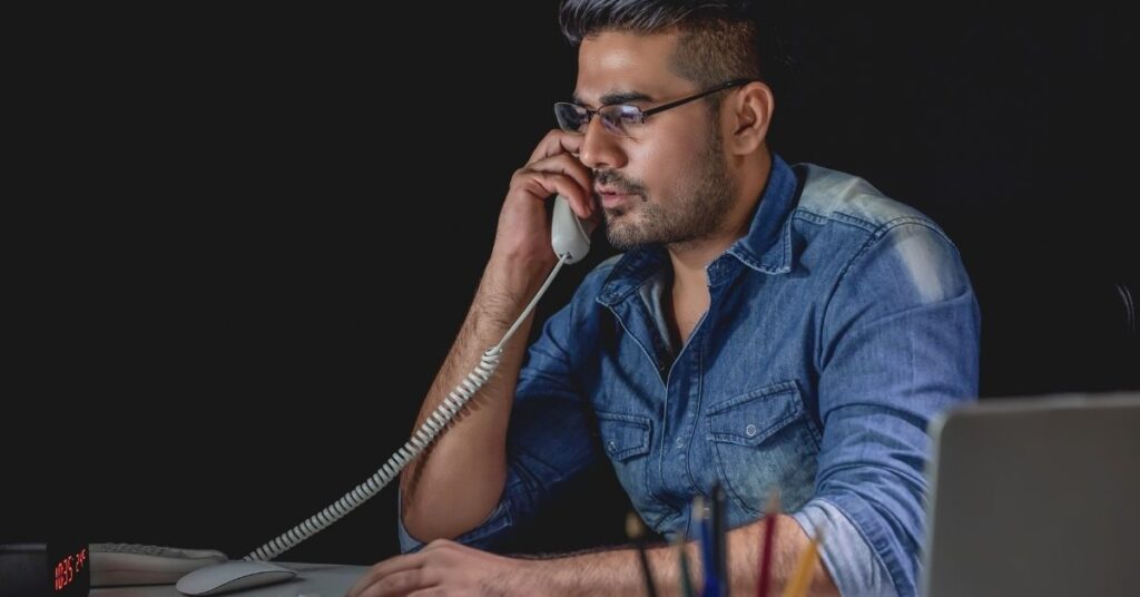 businessman answering phone call at night in the office