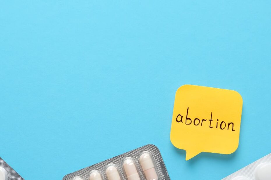 Paper Note with Word Abortion and Pills