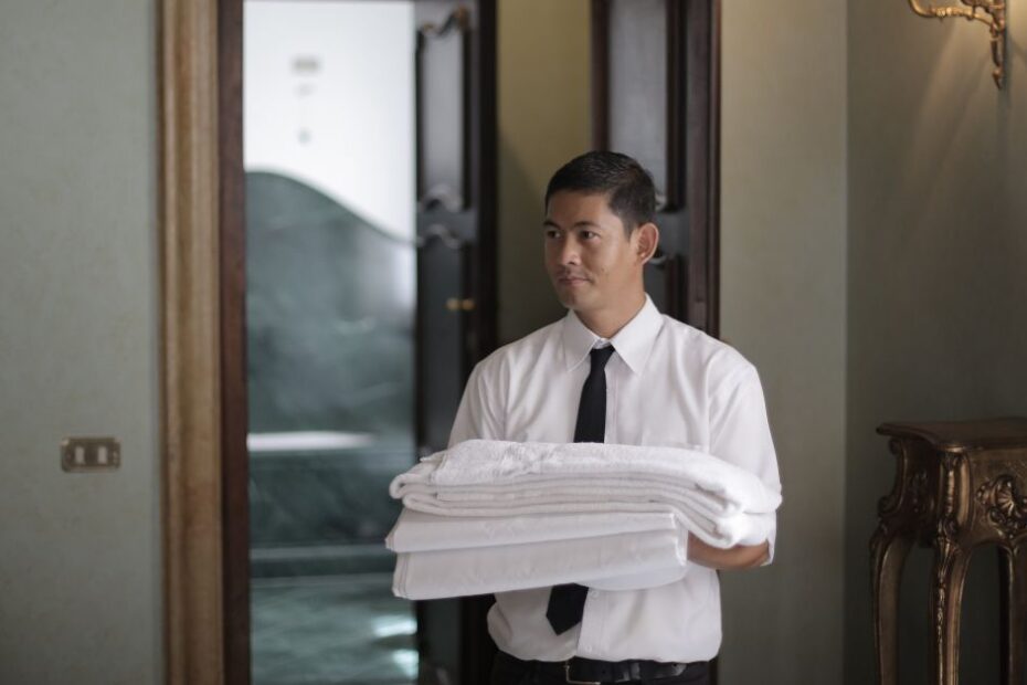 Hotel staff with bed linen