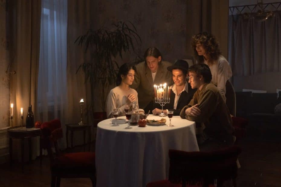 A family gathers around a menorah for a festive Hanukkah dinner, celebrating together indoors.