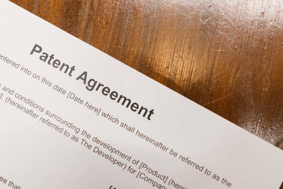 Detailed close-up of a patent agreement document on a polished wooden table.