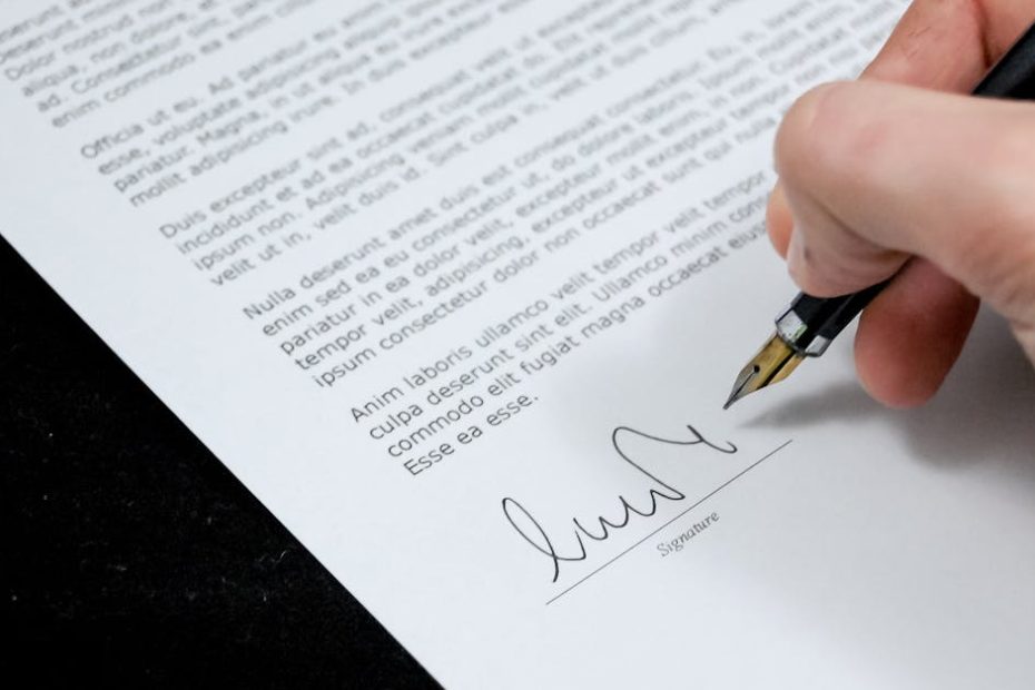 Close-up of a hand signing a formal document with a fountain pen, indicating agreement.
