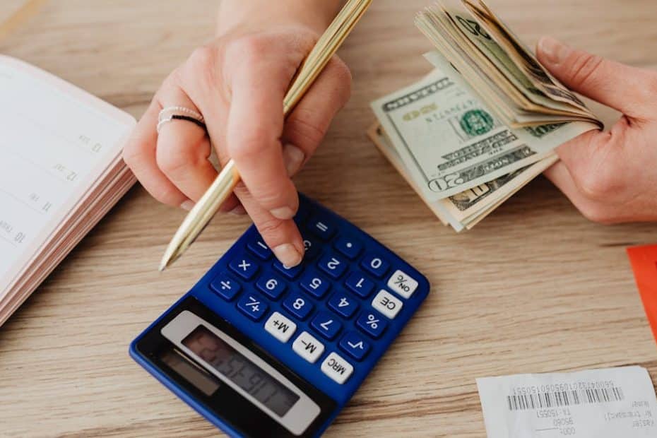 Hands handling cash and calculator for budget planning. Modern financial scene.