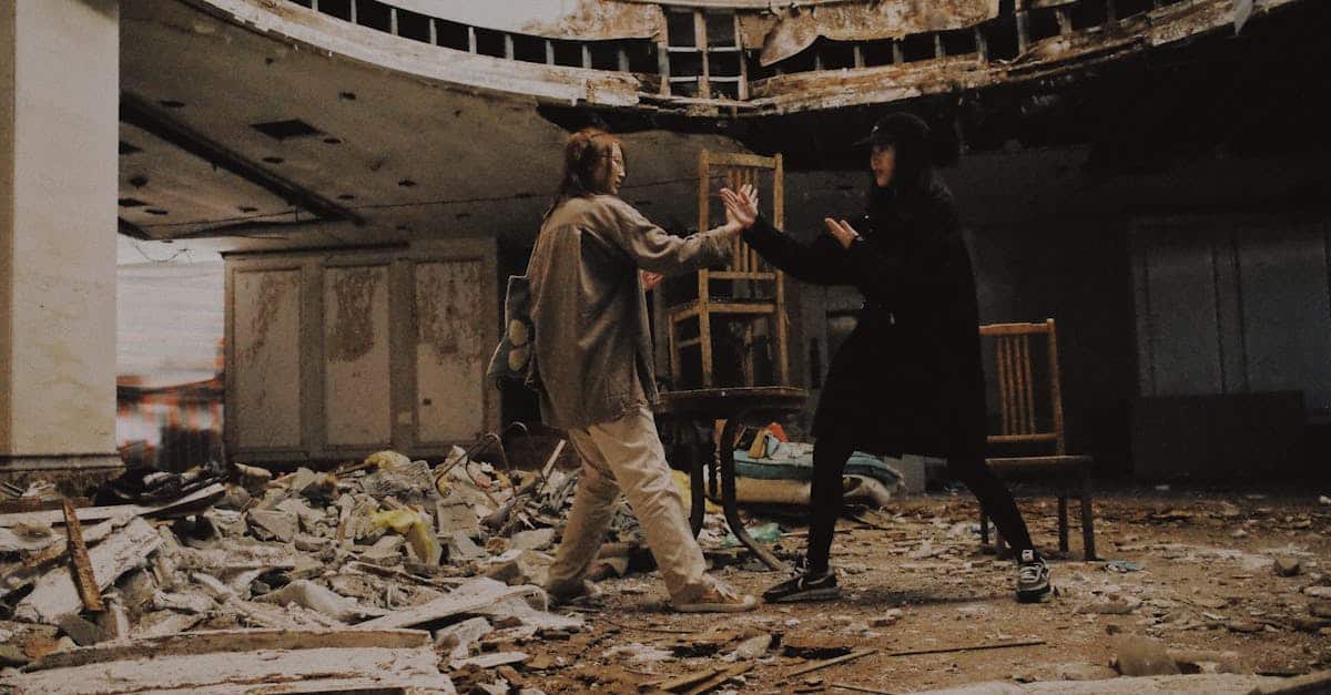 Two individuals pretend to fight in an abandoned, decaying building filled with rubble.