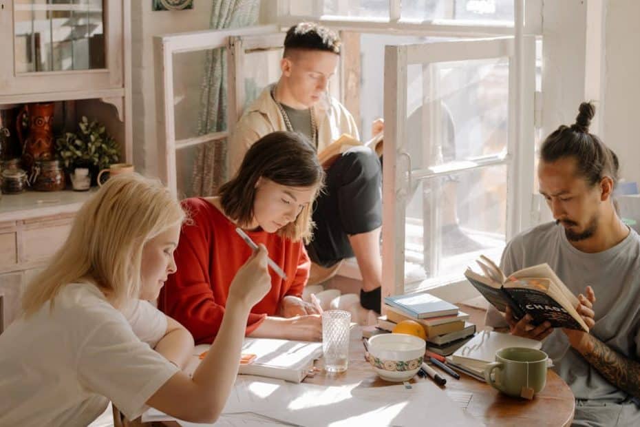 A group of college students studying in a bright, cozy room with natural light.