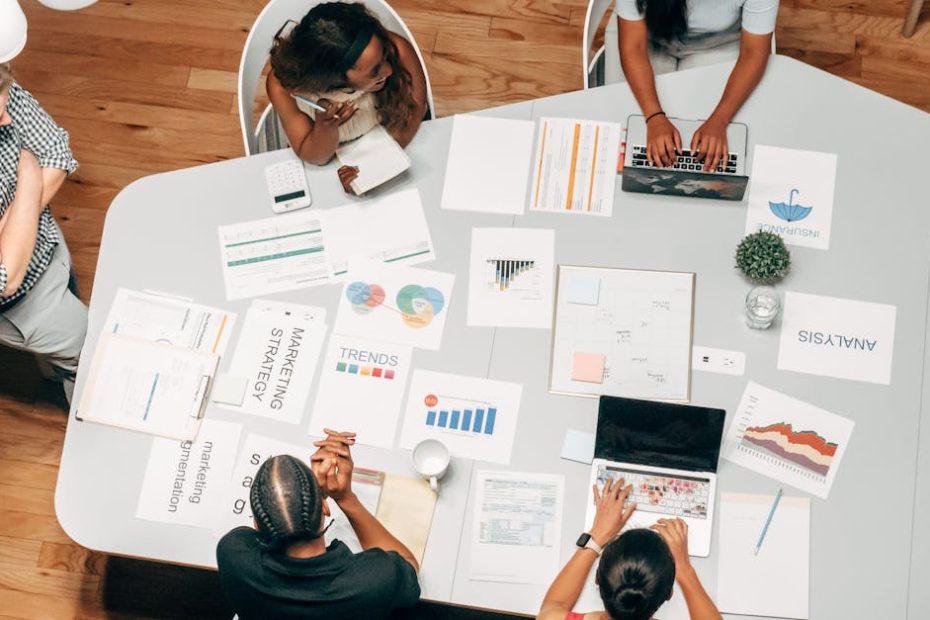 A diverse group working on marketing strategies with charts and laptops in an office setting.