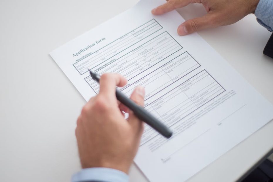 Close-up of a business professional reviewing an application form at a desk.