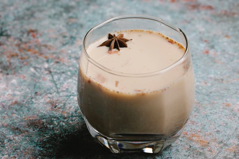 From above of tasty sweet cocktail with milk and spice served on table