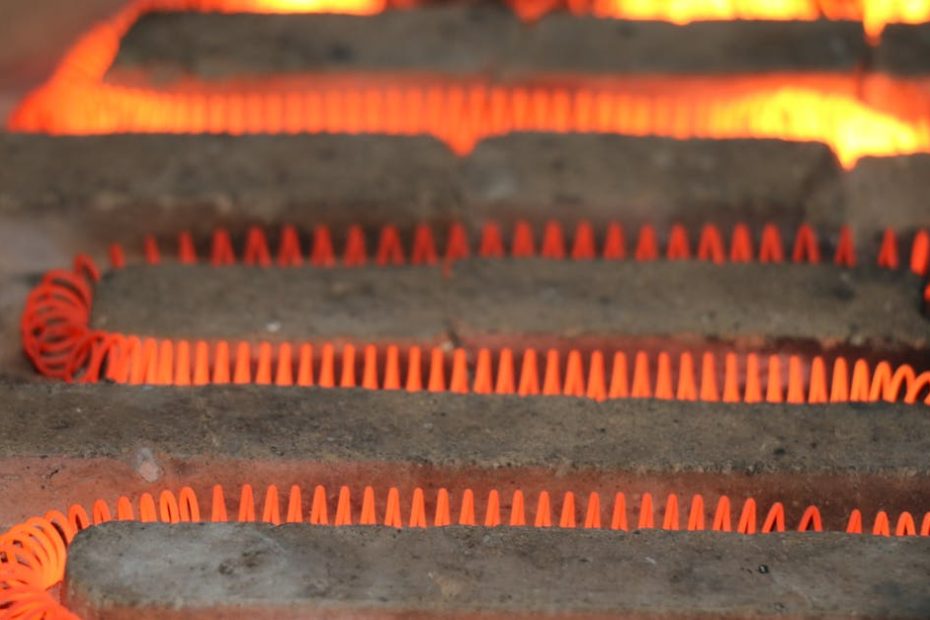 Detailed view of a glowing electric heating element with a coiled structure emitting heat.