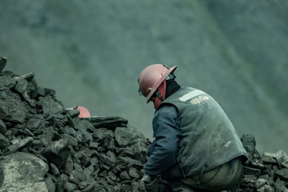 A miner wearing a helmet works in a quarry among rocks in Puno, Peru.