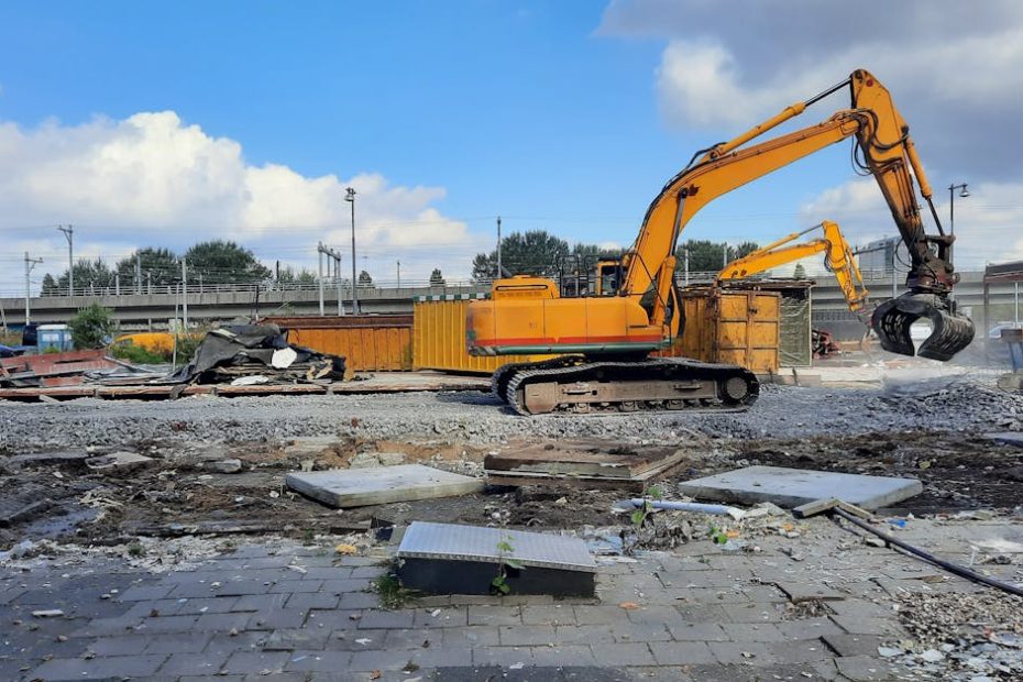A bright yellow excavator working on a construction site in Amsterdam, Netherlands.