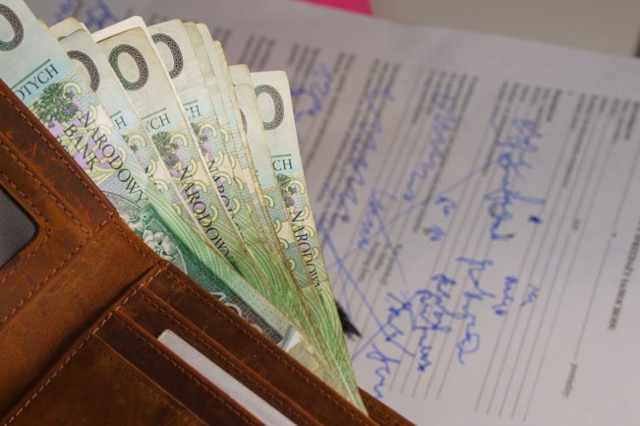 Close-up of a wallet containing Polish Zloty with a signed document in the background, representing financial transactions.