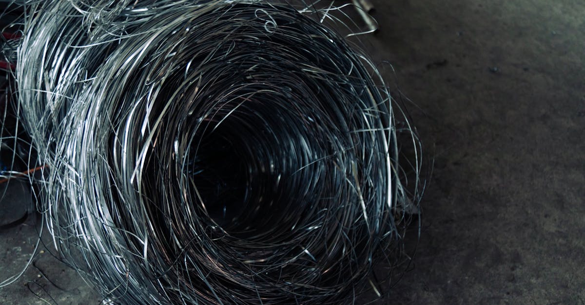 A roll of coiled metal wire in a factory setting, highlighting industrial textures.