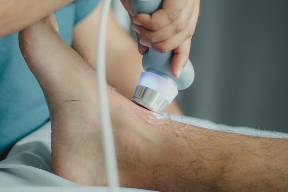 Professional physiotherapist using ultrasound device for leg treatment.