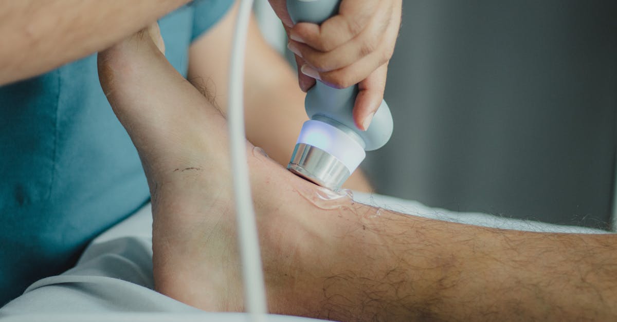 Professional physiotherapist using ultrasound device for leg treatment.