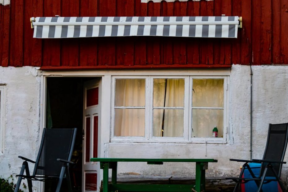 Charming rustic cabin with red and white facade and outdoor seating. Perfect for a cozy retreat.