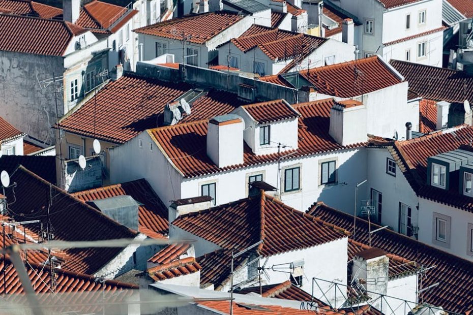 Explore the picturesque red rooftops of Lisbon, Portugal, under clear sunlight.