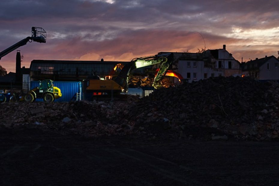 Excavation site with construction equipment during twilight, showcasing a dramatic sky.