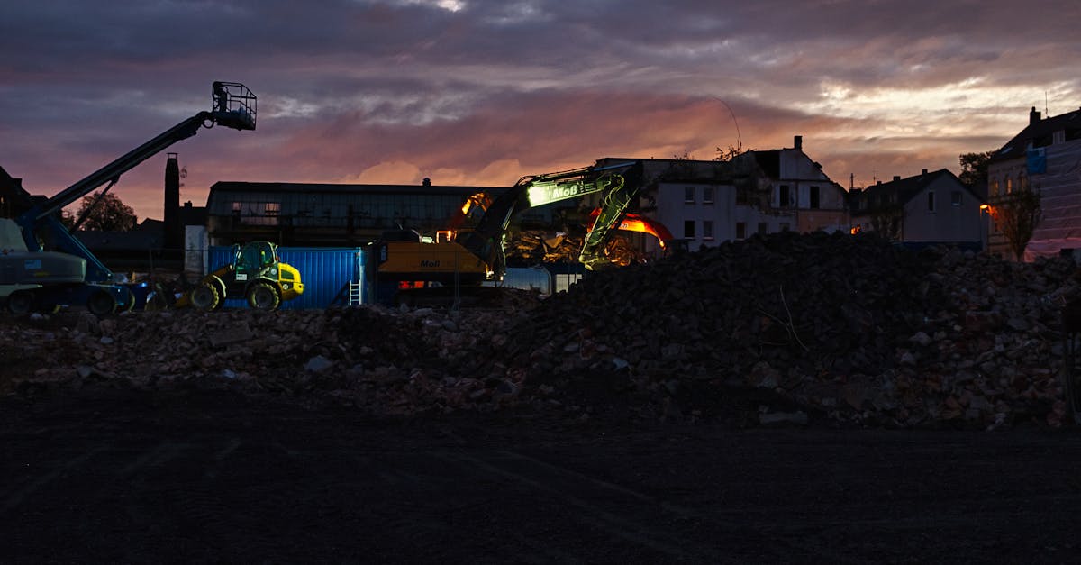 Excavation site with construction equipment during twilight, showcasing a dramatic sky.